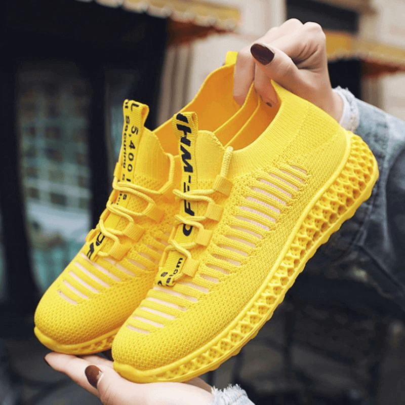 Vibrant yellow mesh breathable sneakers for women, featuring a lace-up design and flat bottoms for style and comfort.